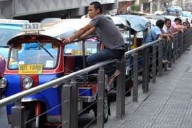 Lái xe tuktuk Thái Lan đợi khách hàng tại trung tâm thương mại ở thủ đô B​angkok. (Nguồn: AFP/TTXVN)