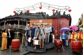 Du khách quốc tế chụp ảnh lưu niệm tại Chùa Cầu, Hội An. (Ảnh: Nguyễn Sơn/TTXVN)