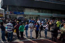Người dân Venezuela xếp hàng chờ giao dịch bên ngoài Ngân hàng Trung ương ở Caracas ngày 17/12/2016. (Nguồn: EPA/TTXVN)
