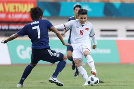 Tiền vệ Quang Hải (19) trong một pha tranh bóng với cầu thủ đội tuyển Olympic Nhật Bản. (Ảnh: Hoàng Linh/TTXVN)