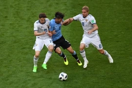 Pha tranh bóng giữa cầu thủ Rodrigo Bentancur (giữa) đội Uruguay và các cầu thủ Yuri Gazinskiy (phải) và Aleksey Miranchuk (trái) đội Nga . (Nguồn: AFP/TTXVN)