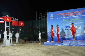 Lễ thượng cờ các nước có vận động viên đoạt giải vàng, bạc, đồng của môn thi đấu đá cầu đơn nam. (Ảnh: Trần Lê Lâm/TTXVN)