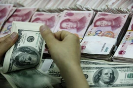 Kiểm đồng USD (phía trước) và đồng nhân dân tệ tại một ngân hàng ở Hoài Bắc, tỉnh An Huy, Trung Quốc. (Nguồn: AFP/TTXVN) 