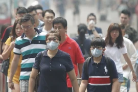 Người dân Singapore đeo khẩu trang để đối phó với tình trạng ô nhiễm khói bụi. (Nguồn: Reuters/TTXVN)