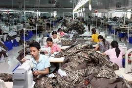 May gia công quần áo xuất khẩu. (Ảnh: Đình Huệ/TTXVN)