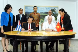 Hai đồng Chủ tịch Ủy ban liên Chính phủ Việt Nam-Cuba: Bộ trưởng Bộ Xây dựng Việt Nam Phạm Hồng Hà (trái) và Bộ trưởng Bộ Ngoại thương và Đầu tư nước ngoài Cuba Rodrigo Malmierca Díaz (phải) ký biên bản kỳ họp. (Ảnh: Lê Hà/TTXVN) 
