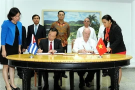 Hai đồng Chủ tịch Ủy ban liên Chính phủ Việt Nam-Cuba: Bộ trưởng Bộ Xây dựng Việt Nam Phạm Hồng Hà (trái) và Bộ trưởng Bộ Ngoại thương và Đầu tư nước ngoài Cuba Rodrigo Malmierca Díaz (phải) ký biên bản kỳ họp. (Ảnh: Lê Hà/TTXVN) 