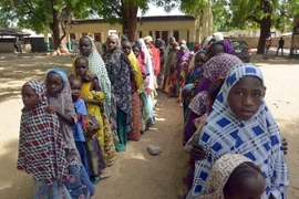 Các em nhỏ vô gia cư Nigeria nhận hàng viện trợ tại khu trại gần Zabarmari, ngoại ô Maiduguri, Đông Bắc Nigeria. (Nguồn: AFP/TTXVN)