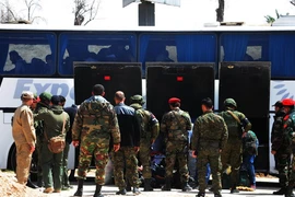 Binh sỹ Nga và Syria giám sát việc sơ tán của lực lượng nổi dậy và gia đình tại Đông Ghouta ngày 29/3. (Nguồn: THX/TTXVN)