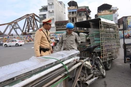 Cảnh sát giao thông Đội 1, Công an Hà Nội kiểm tra, xử lý xe chở hàng cồng kềnh. (Ảnh: Doãn Tấn/TTXVN)