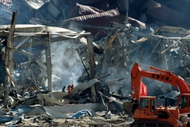 Lực lượng chức năng làm nhiệm vụ tại hiện trường vụ nổ ngày 21/8. (Nguồn: THX/TTXVN)