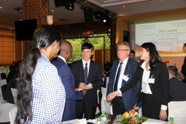 Chủ tịch Ủy ban Nhân dân tỉnh Thanh Hóa Nguyễn Đình Xứng (thứ ba từ phải sang) trao đổi với đại diện một số doanh nghiệp tham dự hội nghị. (Ảnh: Phùng Anh Đức/TTXVN)