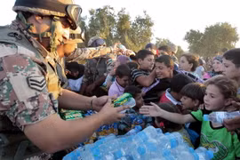 Binh sỹ Jordan phân phát nước uống và lương thực cho người tị nạn Syria tại khu vực Ramtha ở biên giới Syria-Jordan ngày 5/9/2012. (Nguồn: AFP/TTXVN)
