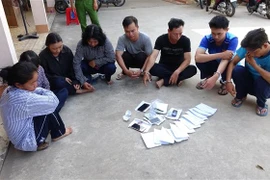 Các đối tượng tham gia đánh bạc và tổ chức đánh bạc bị bắt giữ. (Ảnh: Thanh Tân/TTXVN) 