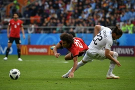 Pha tranh bóng quyết liệt giữa cầu thủ Amr Warda (trái) của Ai Cập và Martin Caceres của Uruguay trong trận đấu. (Nguồn: THX/TTXVN)