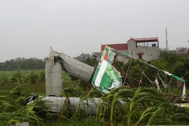 Biển hiệu quảng cáo bị gió bão quật đổ. (Ảnh: Ngọc Hà/TTXVN)