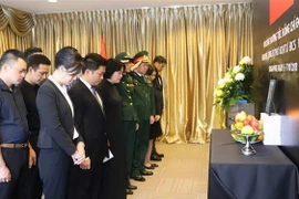 Cán bộ, nhân viên Đại sứ quán Việt Nam tại Singapore mặc niệm tưởng nhớ nguyên Tổng Bí thư Đỗ Mười. (Ảnh: Xuân Vịnh/TTXVN)