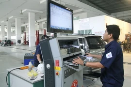 Đăng kiểm viên kiểm tra thông số kỹ thuật xe ôtô qua hệ thống máy tính. (Ảnh: Hoàng Hùng/TTXVN)