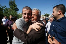 Phóng viên Mohammed al-Qiq (trái) vui mừng gặp lại người thân tại làng Dura - quê hương của anh, ở phía nam Bờ Tây sau khi được Israel trả tự do. (Nguồn: AFP/TTXVN)