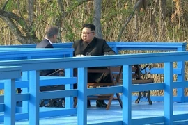Tổng thống Hàn Quốc Moon Jae-in (trái) và nhà lãnh đạo Triều Tiên Kim Jong-un trong cuộc thảo luận trên một cây cầu gỗ tại làng đình chiến Panmunjom ngày 27/4. (Nguồn: Yonhap/TTXVN)