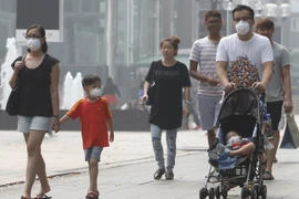 Người dân Singapore đeo khẩu trang để đối phó với tình trạng ô nhiễm khói bụi. (Nguồn: Reuters/TTXVN)