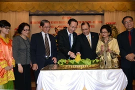Phó Chủ tịch Ủy ban Nhân dân Thành phố Hồ Chí Minh Lê Thanh Liêm và Tổng lãnh sự Indonesia Jean Anes cắt bánh truyền thống của Indonesia tại Lễ kỷ niệm. (Ảnh: Thanh Vũ/TTXVN)