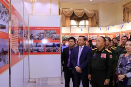 Thượng tướng Thongloy Silivong, Thứ trưởng, Chủ nhiệm Tổng cục Chính trị Bộ Quốc phòng Lào và Đại sứ Việt Nam tại Lào Nguyễn Bá Hùng cùng các quan khách tham quan Triển lãm. (Ảnh: Phạm Kiên/TTXVN) 