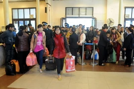 Hành khách chuẩn bị lên tàu để về quê đón Tết tại ga Hà Nội. (Ảnh: Quang Quyết/TTXVN)