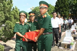 Lễ an táng các hài cốt liệt sỹ. (Ảnh: Hồ Cầu/TTXVN)