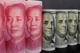 Đồng tiền giấy 100 nhân dân tệ (trái) và đồng USD ở Bắc Kinh. (Nguồn: Reuters/TTXVN)