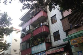 Cậu bé đang treo lơ lửng ngoài ban công. (Nguồn: QQ)