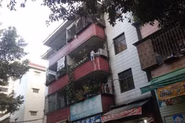 Cậu bé đang treo lơ lửng ngoài ban công. (Nguồn: QQ)