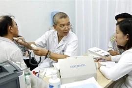 Phó giáo sư, tiến sỹ Nguyễn Hữu Ước, Giám đốc Trung tâm Tim mạch-Lồng ngực (Bệnh viện Hữu nghị Việt Đức), khám và tư vấn phát hiện sớm và điều trị bệnh động mạch vành cho người dân. (Ảnh: Dương Ngọc/TTXVN) 