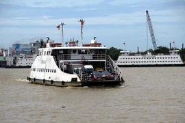 Hành khách và các phương tiện giao thông đi phà Cát Lái. (Ảnh: Hoàng Hải/TTXVN)