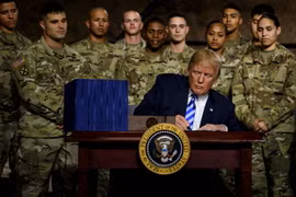 Tổng thống Mỹ Donald Trump (phía trước) ký ban hành Đạo luật Chi tiêu Quốc phòng (NDAA) tài khóa 2019 tại căn cứ Fort Drum ở New York ngày 13/8. (Nguồn: AFP/TTXVN)