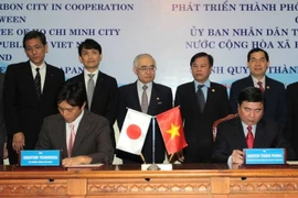 Chủ tịch Ủy ban Nhân dân Thành phố Hồ Chí Minh Nguyễn Thành Phong và Thị trưởng Hirofumi Yoshimura ký bản ghi nhớ về phát triển Thành phố phát thải carbon thấp. (Ảnh: Thanh Vũ/TTXVN)