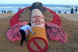 Nhà điêu khắc trên cát nổi tiếng Ấn Độ Sudarsan Pattnaik thể hiện tác phẩm "Ngày Thế giới không thuốc lá" trên bãi biển Puri. (Nguồn: AFP/TTXVN)