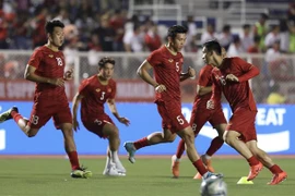 Các cầu thủ Việt Nam khởi động. (Ảnh: Hoàng Linh/TTXVN) 