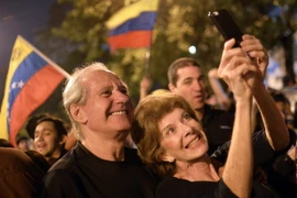 Những người ủng hộ Liên minh đối lập mừng chiến thắng tại thủ đô Caracas, sau khi công bố kết quả. (Nguồn: AFP/TTXVN)