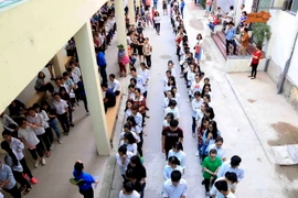 Thí sinh xếp hàng vào phòng thi đánh giá năng lực môn Ngoại ngữ trên máy tính tại Đại học Quốc gia Hà Nội, sáng 5/5. (Ảnh: Quý Trung/TTXVN)