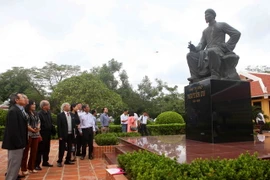 Du khách bên tượng Đại thi hào Nguyễn Du tại khu lưu niệm. (Ảnh: Thanh Tùng/TTXVN)