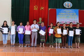 Đại diện cơ quan chức năng tỉnh Quảng Trị trao Quyết định nhập Quốc tịch Việt Nam cho người dân. (Ảnh: Nguyên Lý/TTXVN) 