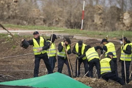 Các chuyên gia Hà Lan và Malaysia làm nhiệm vụ tại khu vực rơi máy bay MH17 ngày 23/4. (Nguồn: AFP/TTXVN)