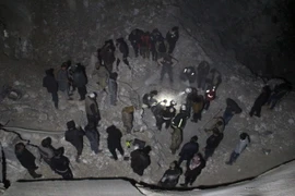 Lực lượng tình nguyện Syria tìm kiếm các nạn nhân dưới đống đổ nát của đền thờ Hồi giáo sau vụ không kích tại làng Al-Jineh ngày 16/3. (Nguồn: AFP/TTXVN)