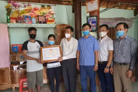 Lãnh đạo Sở Giáo dục và Đào tạo Nghệ An trao bằng khen của Bộ Giáo dục và Đào tạo cho gia đình em Tuấn. (Ảnh: Bộ Giáo dục và Đào tạo)