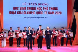 Thủ tướng Nguyễn Xuân Phúc và Bộ trưởng Bộ Giáo dục và Đào tạo Phùng Xuân Nhạ khen thưởng các học sinh. (Ảnh: PV)