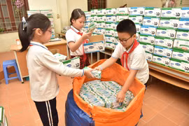 Học sinh thu gom vỏ hộp sữa. (Ảnh: PV)