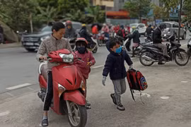 Học sinh Hà Nội đi học trong giá rét. (Ảnh: PM/Vietnam+)