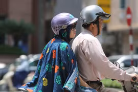 Người dân ra đường với trang phục kín mít để tránh cái nắng gay gắt. (Ảnh: Thành Đạt/TTXVN)
