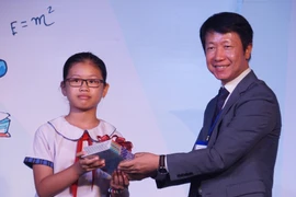 Đại diện Ban tổ chức trao tặng sách cho học sinh. (Ảnh: Thu Hoài/TTXVN)